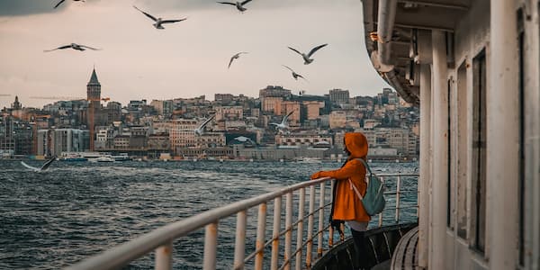 Μια γυναίκα αγναντεύει την Κωνσταντινούπολη ενώ κάνει κρουαζιέρα στον Βόσπορο.